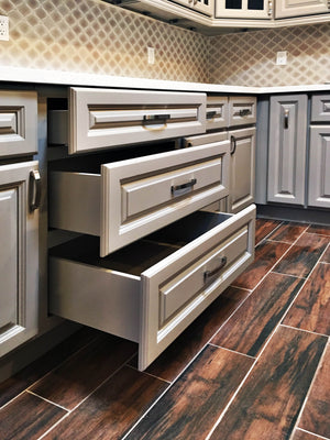 Image Title Anaheim Gray (Kitchen Cabinet), open drawers with metallic handles.